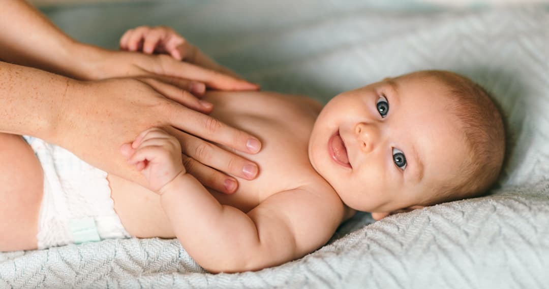 Mom laying baby on a bed