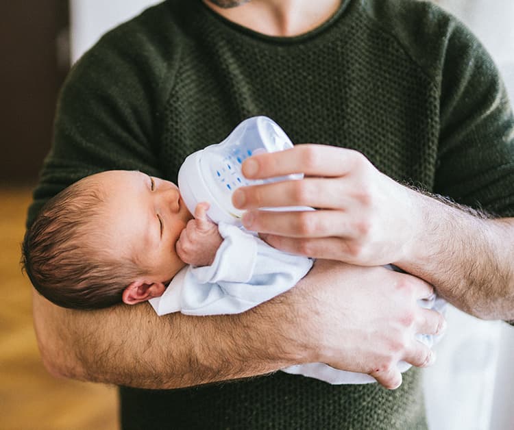 Papá alimentando al bebé con un biberón