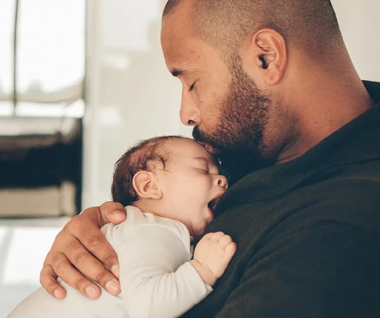 Papá sosteniendo al bebé dormido