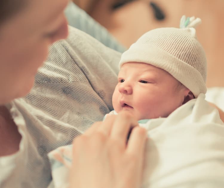 Padre sosteniendo a un bebé prematuro