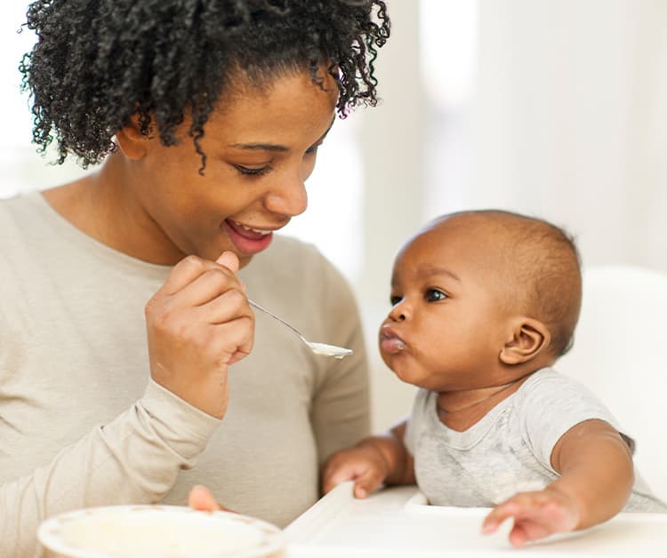 Mom spoon feeding infant